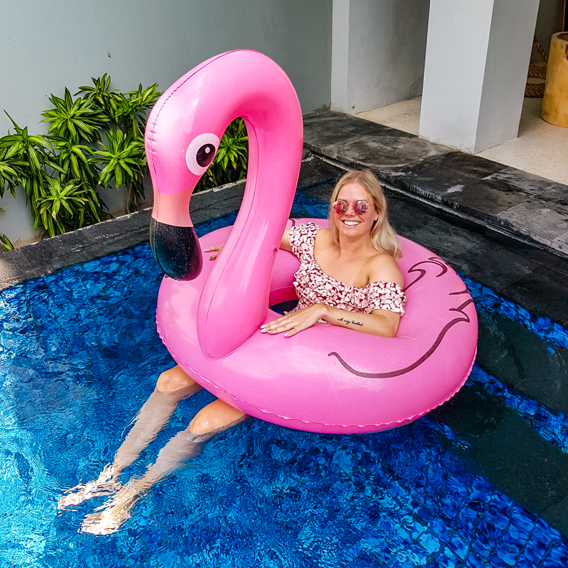 girl and pink flamingo floaty in pool
